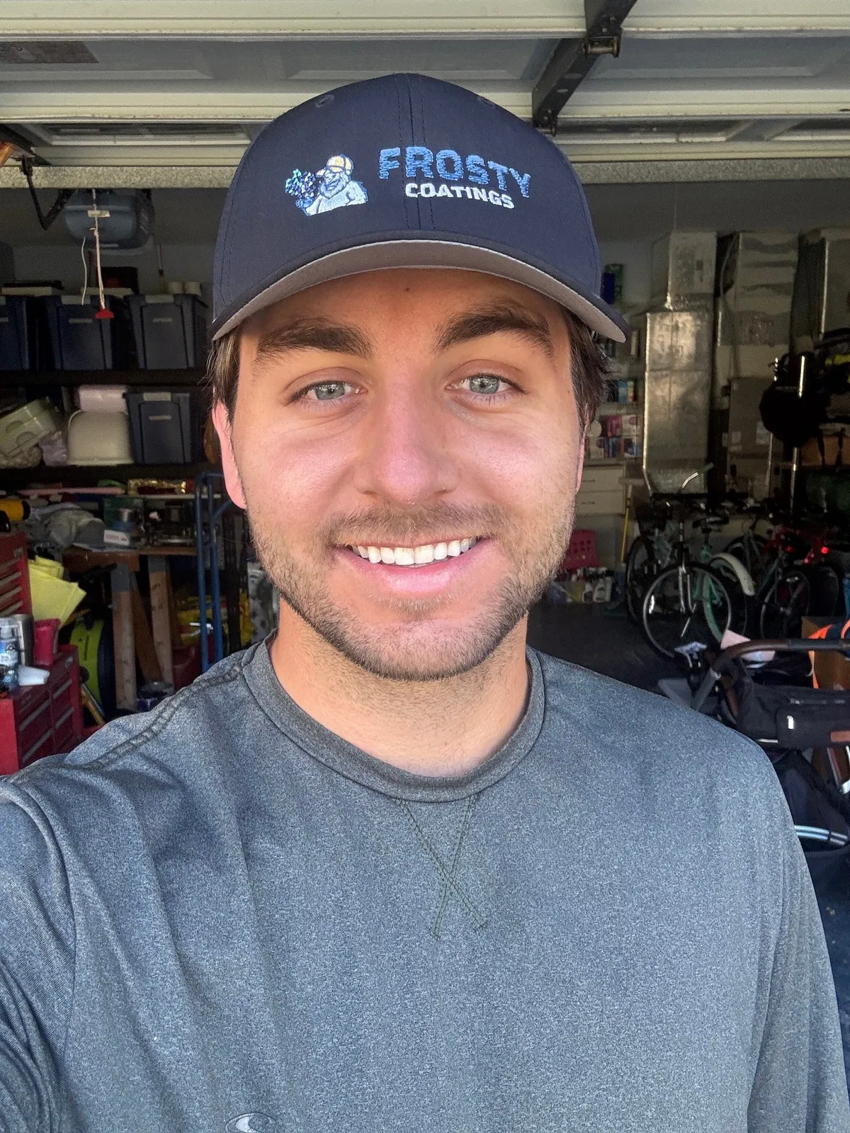 A Frosty Coatings installer in a branded cap in a customer&rsquo;s garage