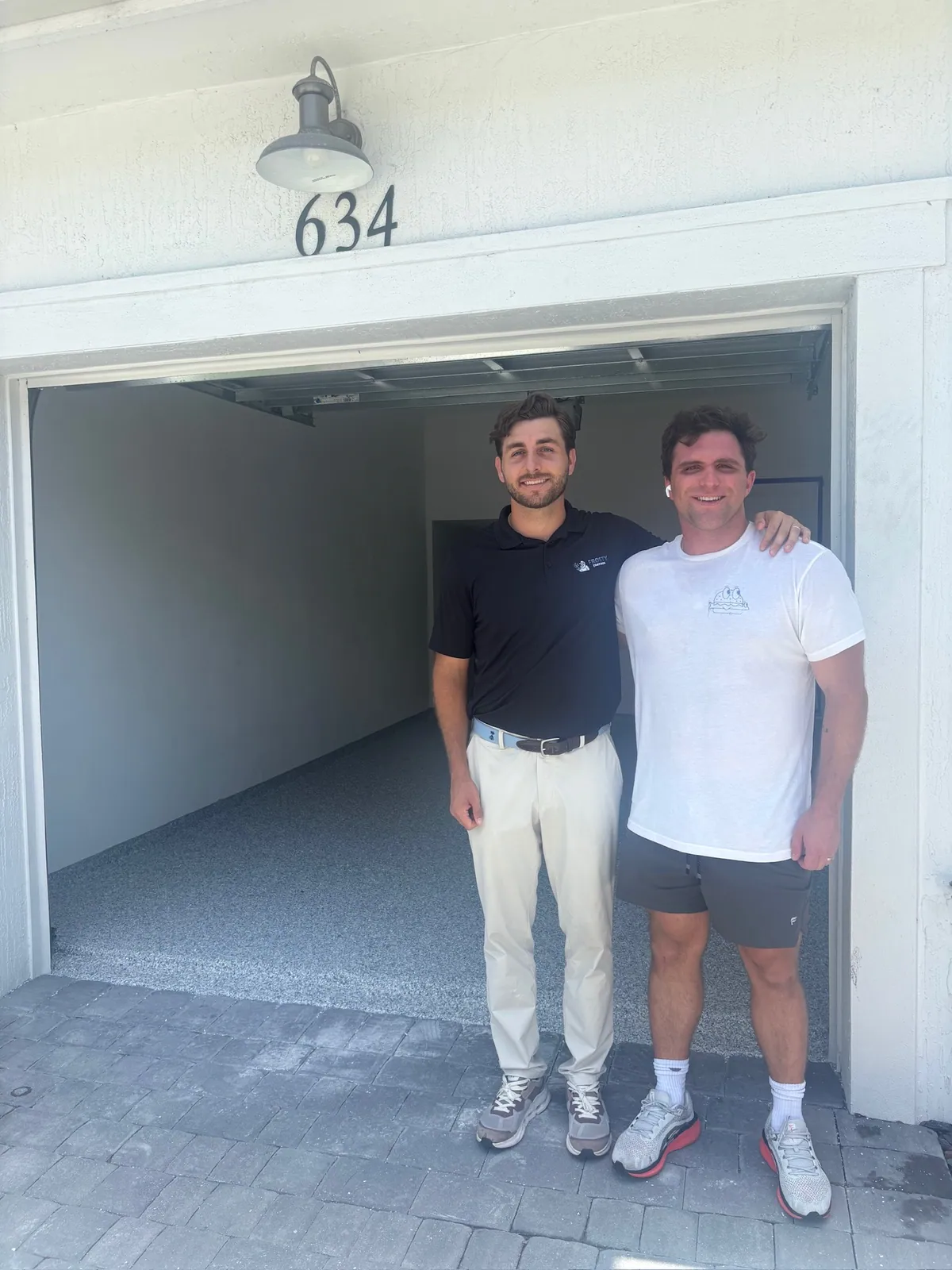 Two of the team outside a finished garage