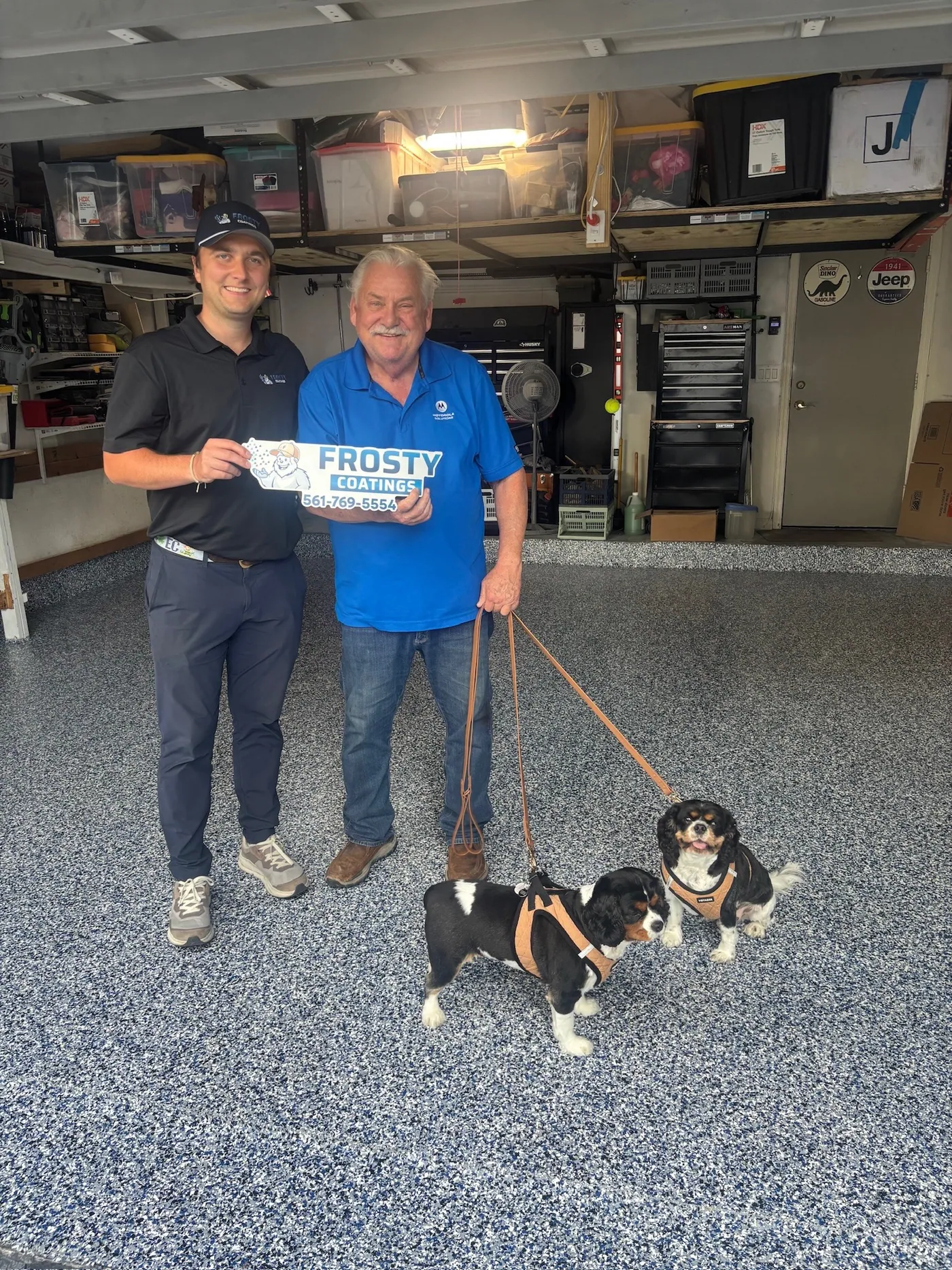 A customer and his two dogs on their new flake floor with a Frosty Coatings installer