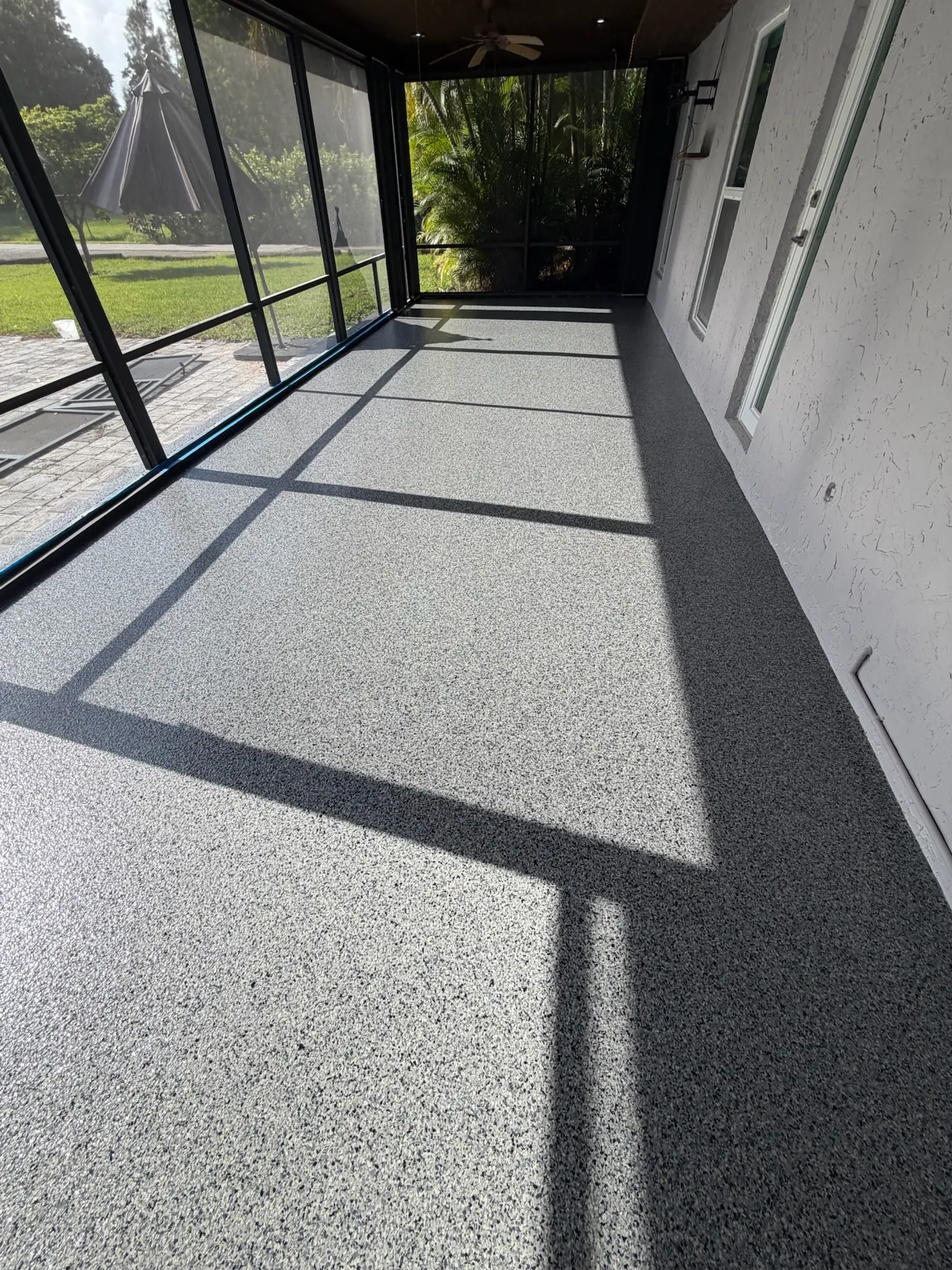 Screened lanai with a flake floor running the length of the cage