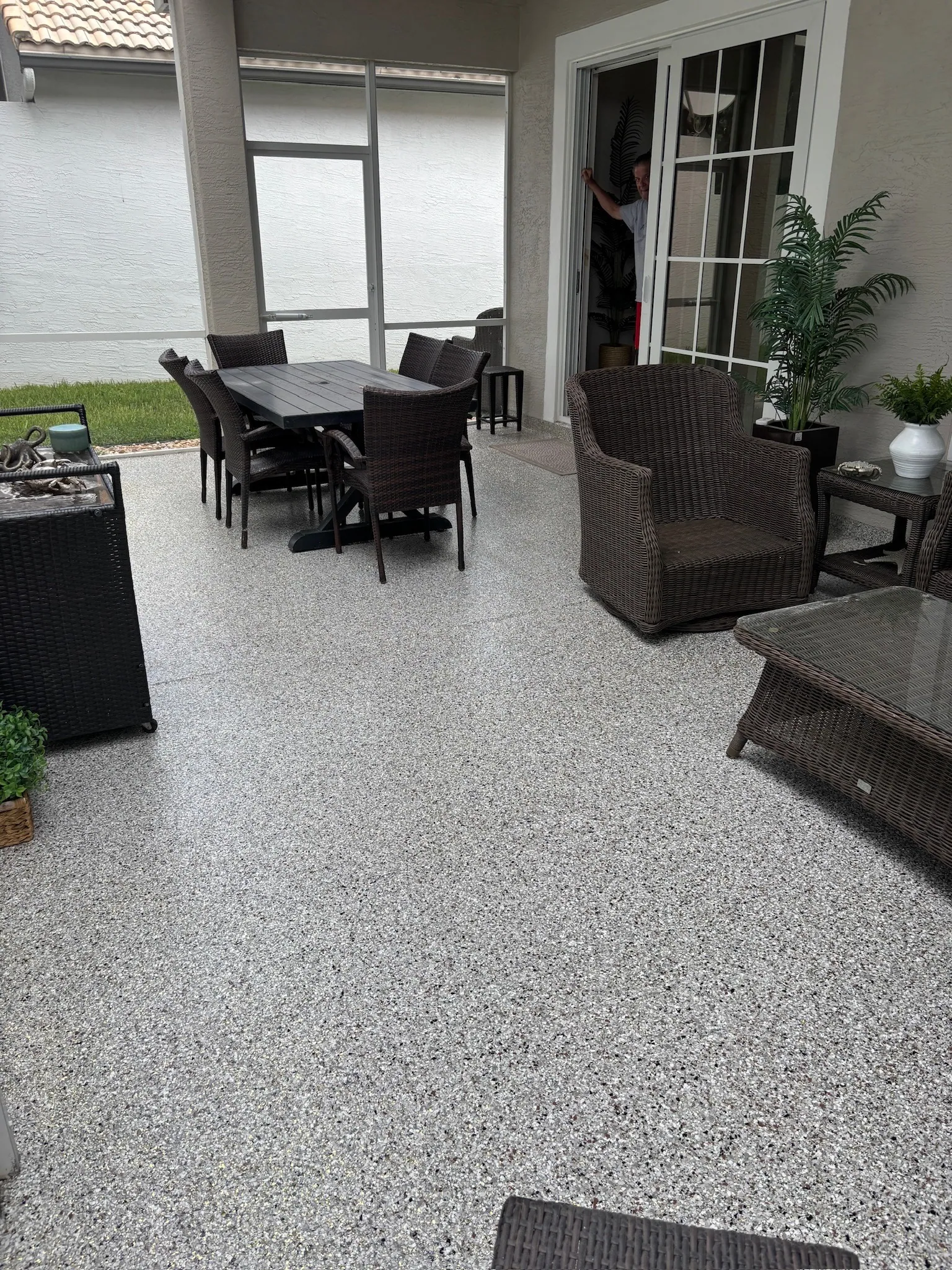 Screened patio with outdoor furniture on a coated floor
