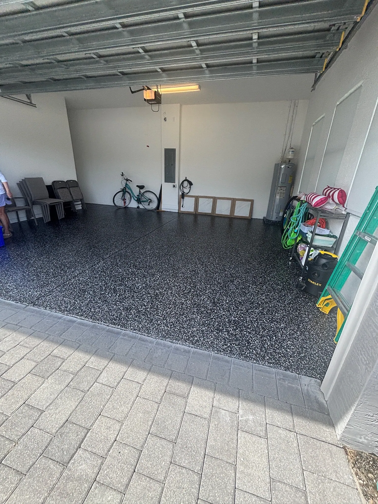 Two car garage in a charcoal flake, doors open onto the paver apron
